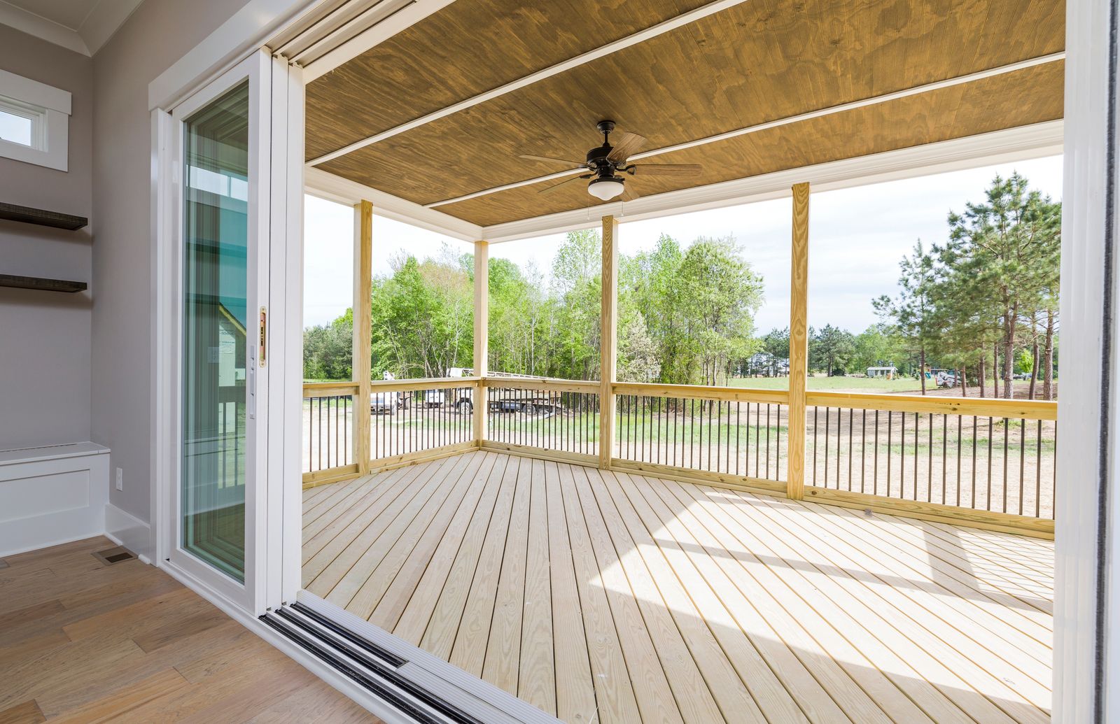 A new covered deck with a wood ceiling and light decking