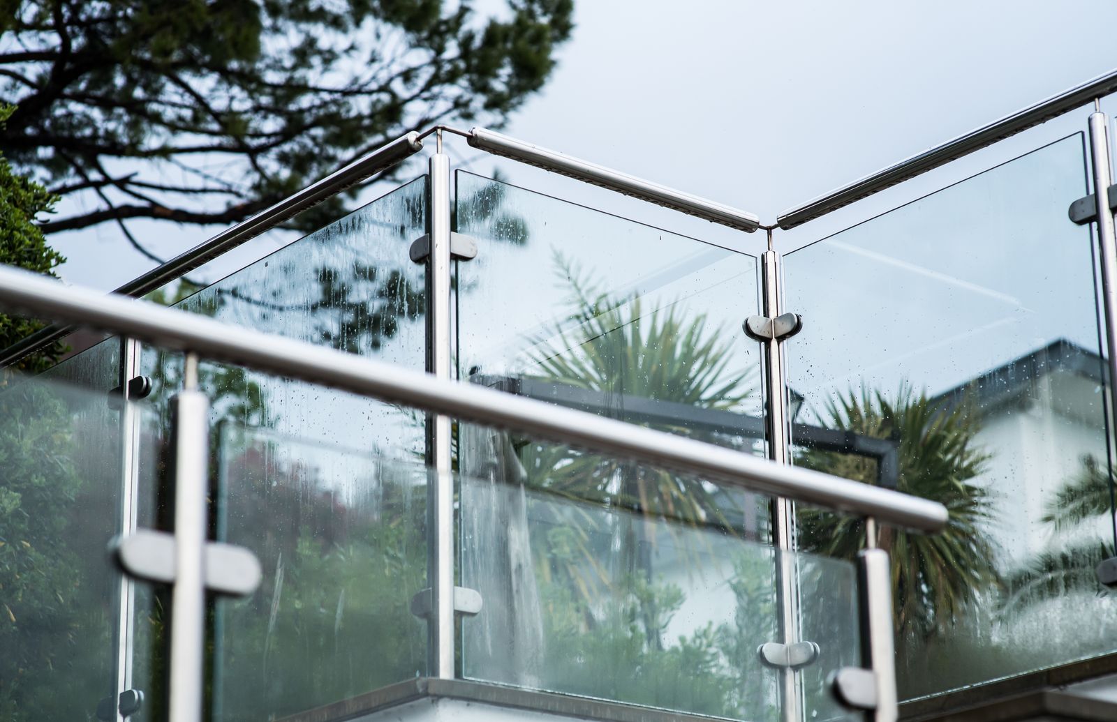 A glass deck railing with stainless posts